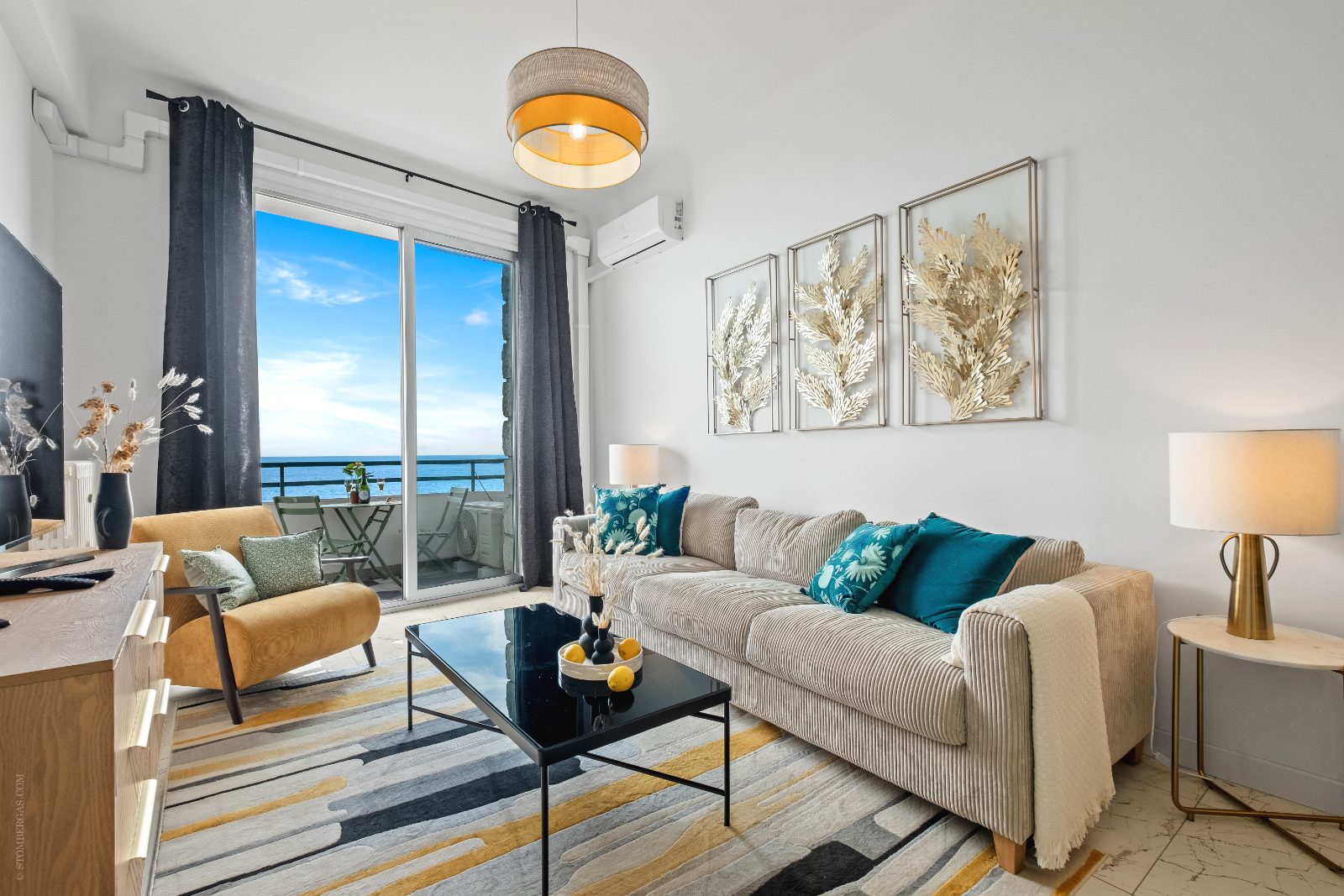 Living room with sofa, armchair and balcony access
